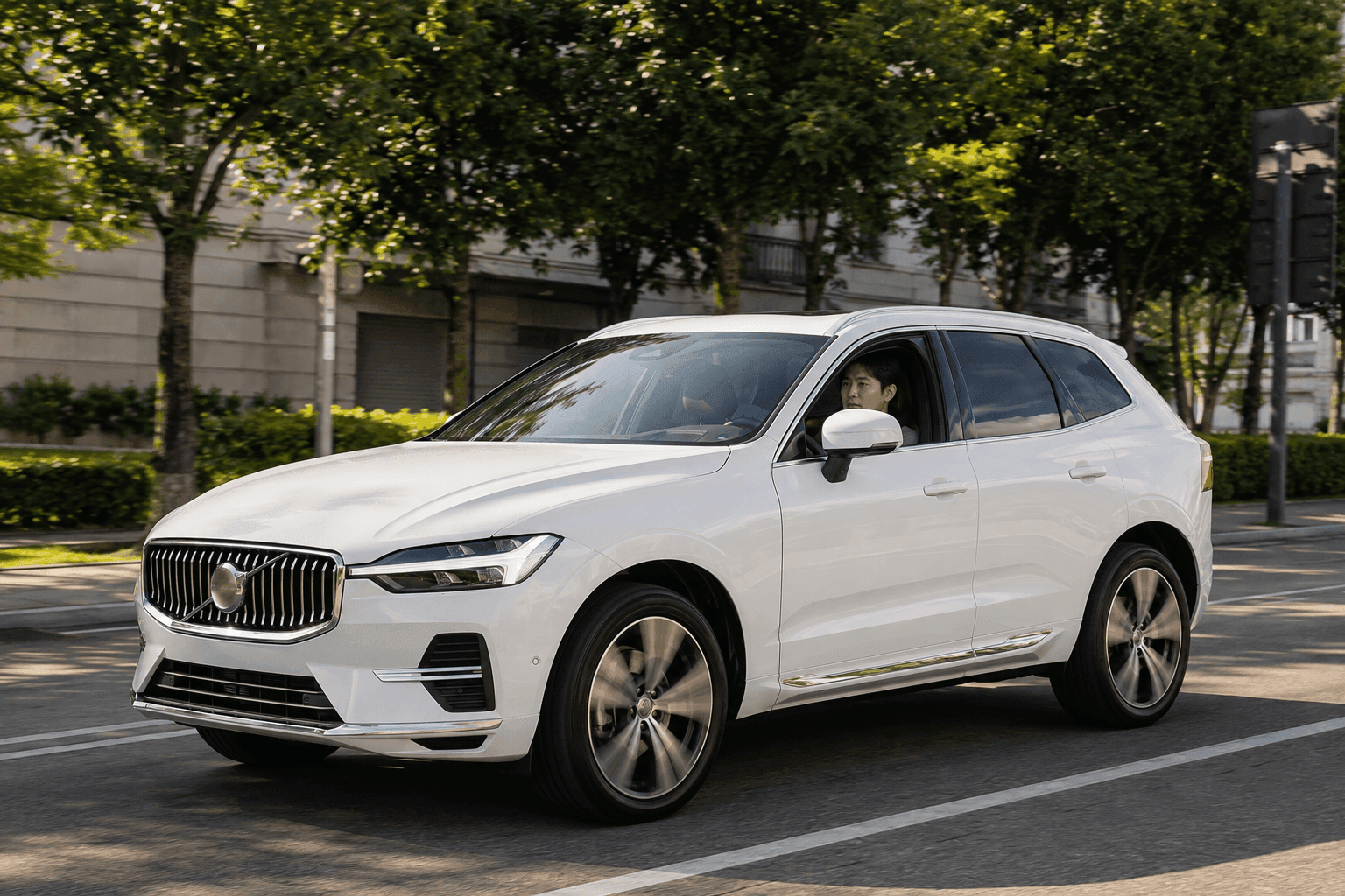 가로수길 도심 도로를 주행 중인 흰색 볼보 XC60